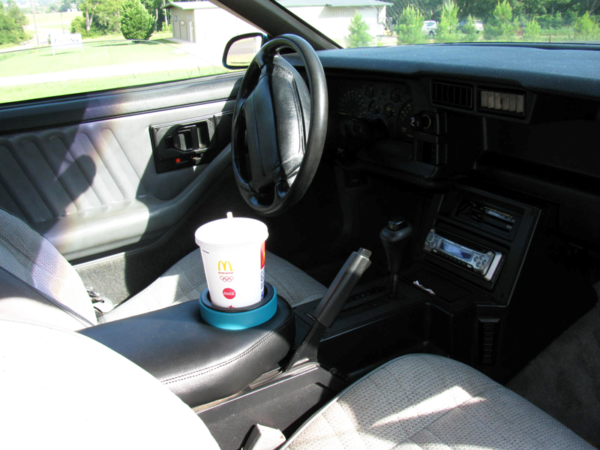 A 1982-1992 Camaro Armrest Pad Cup Holder in a Camaro